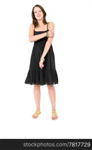 Full body portrait of a young brunette woman in a black summer dress, holding her arm being self aware