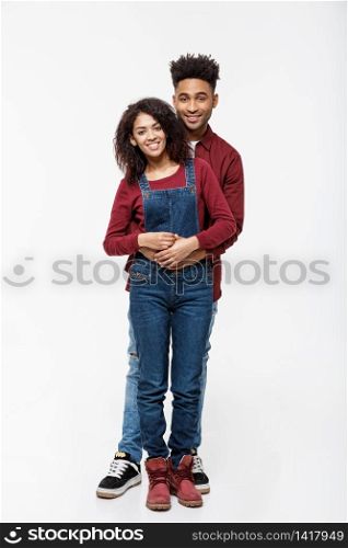 Full body portrait of young African American hugging couple, with smile. Dating, flirting, lovers, romantic studio concept, isolated on white background. Full body portrait of young African American hugging couple, with smile. Dating, flirting, lovers, romantic studio concept, isolated on white background.