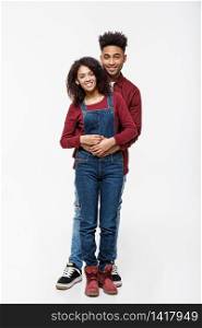 Full body portrait of young African American hugging couple, with smile. Dating, flirting, lovers, romantic studio concept, isolated on white background. Full body portrait of young African American hugging couple, with smile. Dating, flirting, lovers, romantic studio concept, isolated on white background.