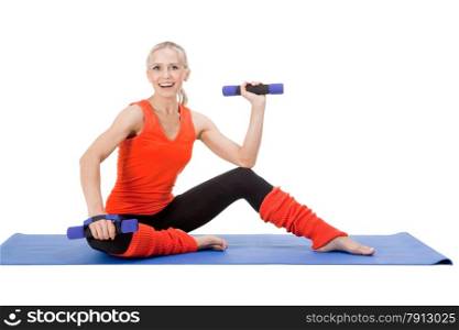 Full body shot of a smiling woman doing exercises with dumb-bells on the mat. Red, green and black colors
