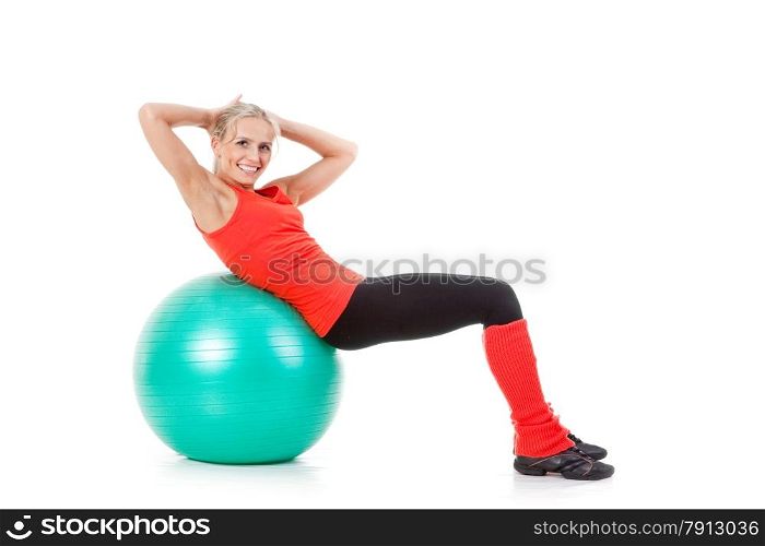 Full body shot of a woman doing exercises with pilates ball. Orange, green and black colors