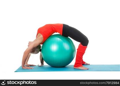 Full body shot of a woman doing exercises with pilates ball on the mat. Orange, green and black colors