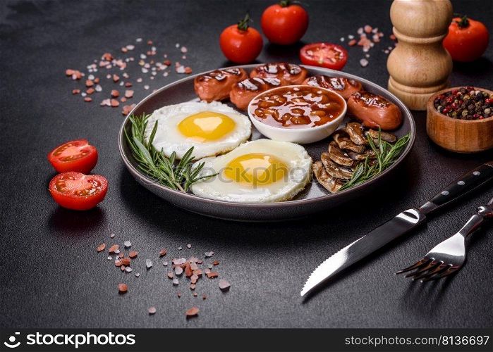 Full english breakfast - bean, fried eggs, roasted sausages, tomatoes, mushrooms on a dark concrete table with toasted bread. Full english breakfast with bean, fried eggs, roasted sausages, tomatoes and mushrooms