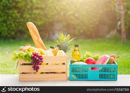 Full fresh vegetables and fruits in crate wood box, harvest organic food on the garden place of green leaves color background for copy space, Eat healthy concept
