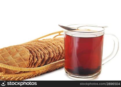 Full glass cup of tea and basket with tasty pastries