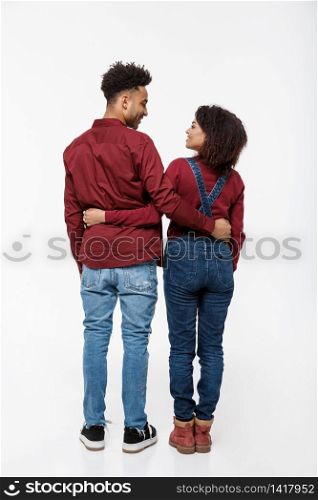 Full lenght back view of young African American couple hugging together isolated on white background.. Full lenght back view of young African American couple hugging together isolated on white background