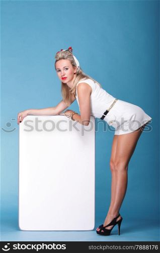 full lenght Beautiful young woman with pin-up make-up and hairstyle posing in studio with white board.