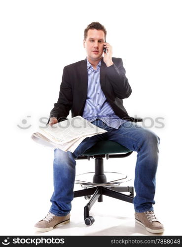 Full length businessman reads newspaper phoning talking on mobile phone commenting economy news isolated on white background