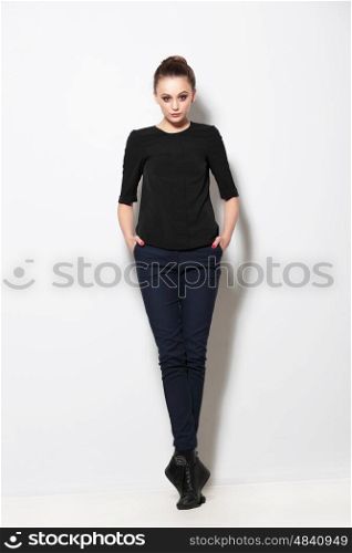 Full length casual young girl posing on light background.