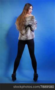 Full length fashionable woman in fur coat long hair back view blue background