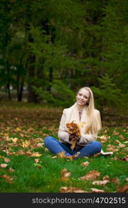 Full length, happy blonde woman in autumn park