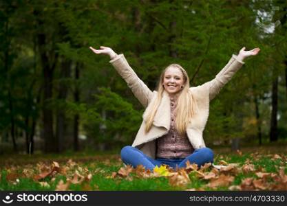 Full length, happy blonde woman in autumn park