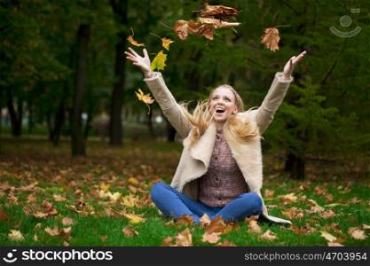 Full length, happy blonde woman in autumn park
