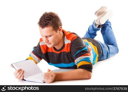 Full length male student lying on floor reading a book preparing for exam isolated on white background