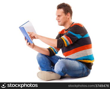 Full length male student sitting on floor reading a book preparing for exam isolated on white background