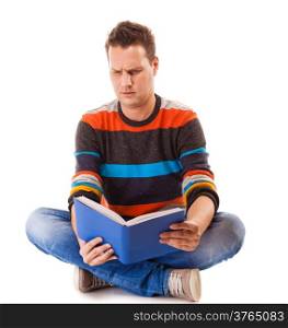 Full length male student sitting on floor reading a book preparing for exam isolated on white background