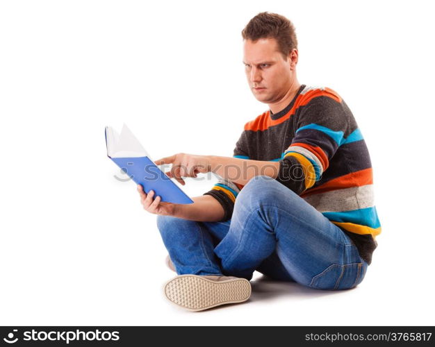 Full length male student sitting on floor reading a book preparing for exam isolated on white background