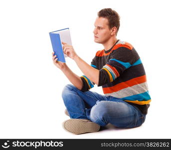 Full length male student sitting on floor reading a book preparing for exam isolated on white background