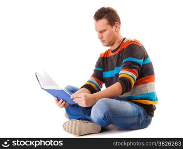 Full length male student sitting on floor reading a book preparing for exam isolated on white background