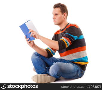 Full length male student sitting on floor reading a book preparing for exam isolated on white background