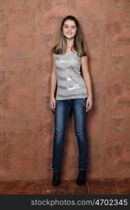 Full length of a beautiful little girl in blue jeans - wall copy space