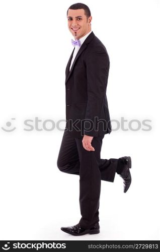 Full length of a business man leaning against the wall on a white isolated background