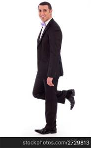 Full length of a business man leaning against the wall on a white isolated background