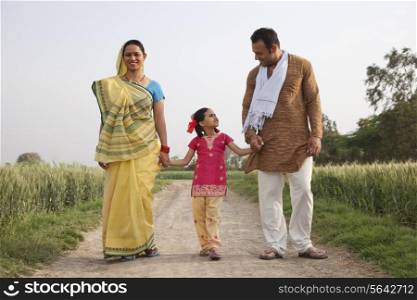 Full length of an Indian family walking on a rural road