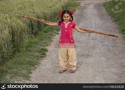 Full length of an Indian girl holding a long stick