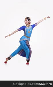 Full length of Bharat Natyam dancer performing over white background