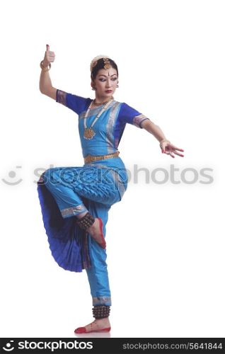 Full length of Bharatanatyam classical dancer performing over white background