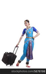 Full length of Bharatanatyam dancer with luggage over white background
