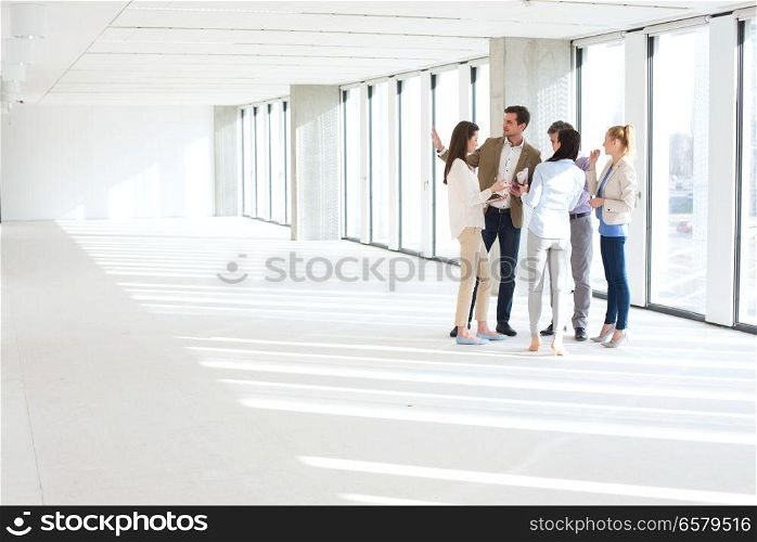 Full length of business people having discussion in empty office space