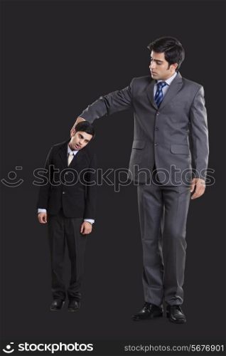 Full length of businessmen holding colleague by collar over black background