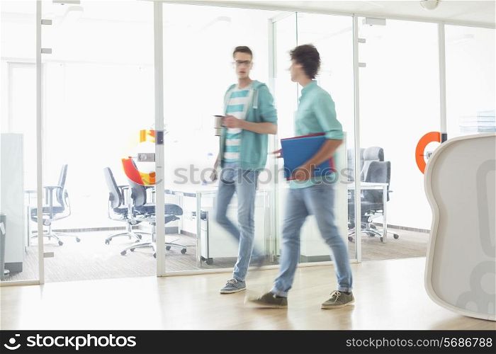 Full-length of businessmen walking at creative work space