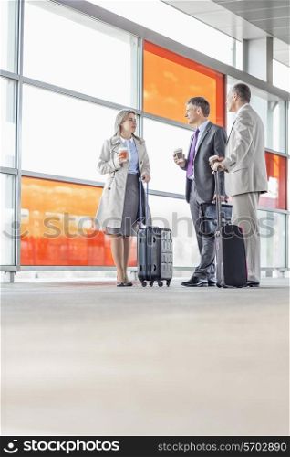 Full length of businesspeople talking on railroad platform
