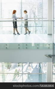 Full-length of businesswomen conversing in office