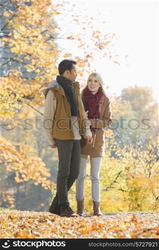 Full length of couple walking in park during autumn
