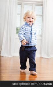 Full length of cute little boy walking on floor at home