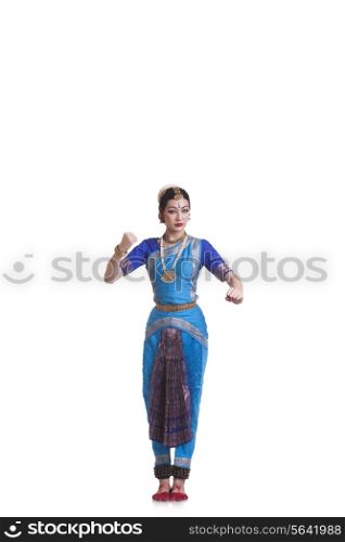 Full length of dancer gesturing while performing Bharatanatyam against white background