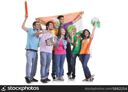 Full length of exhilarated young friends cheering with Indian flag while looking away over white background