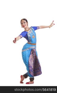 Full length of female dancer performing Bharatanatyam against white background