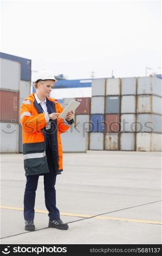 Full-length of female engineer using tablet computer in shipping yard