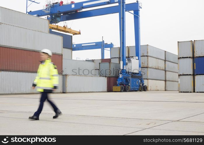 Full-length of female worker walking in shipping yard