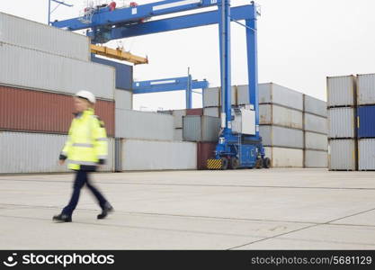 Full-length of female worker walking in shipping yard