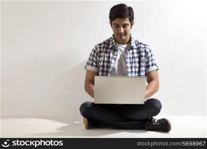 Full length of handsome man using laptop