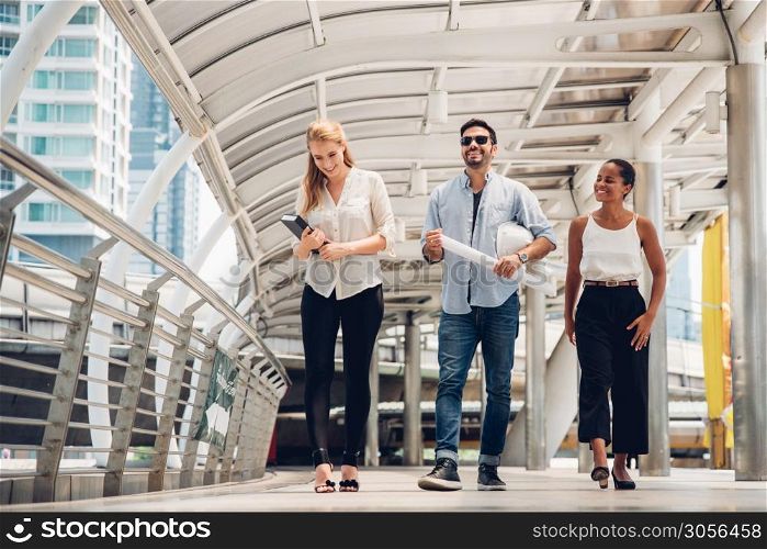 Full Length Of Happy Business People Talking While Walking On Walkway Bridge In City
