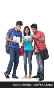 Full length of happy college students using digital tablet over white background