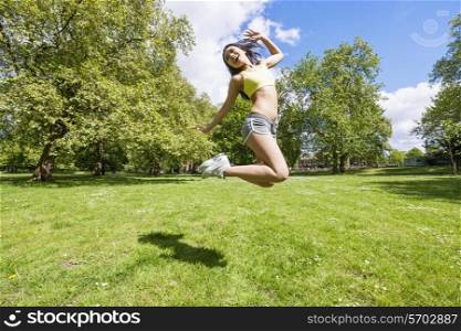 Full length of happy fit woman jumping in park