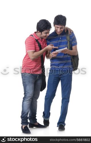 Full length of happy students using digital tablet over white background
